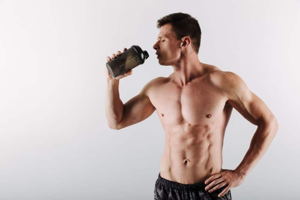 Man with muscles drinking whey protein