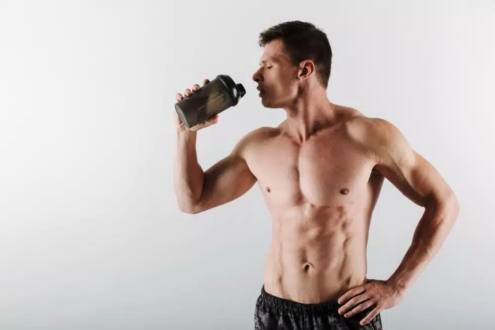 Man with muscles drinking whey protein