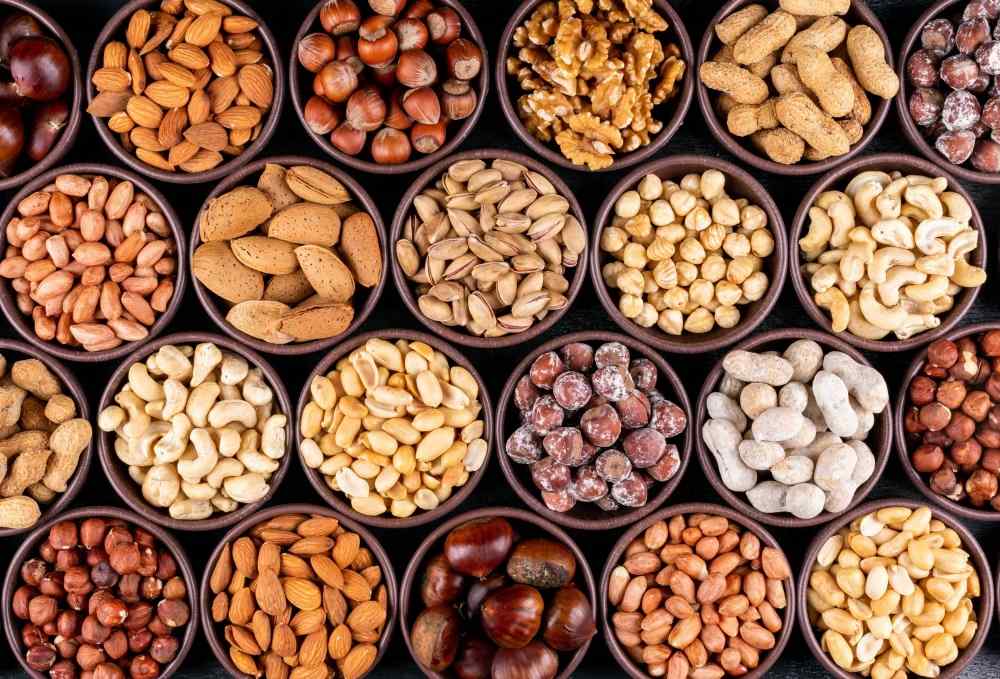 Variety of nuts and oilseeds, walnuts, almond, groundnut, garden cress seeds, gingelly seeds