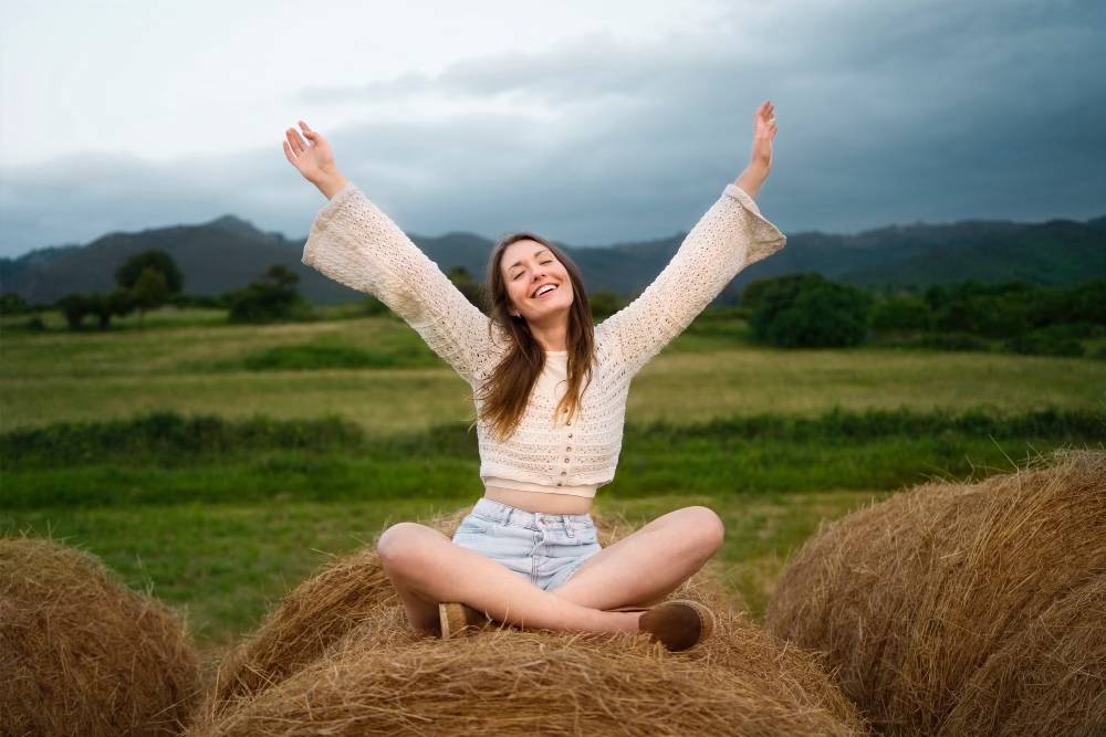 woman sitting in nature raising her arms for mental peace, mental health matters