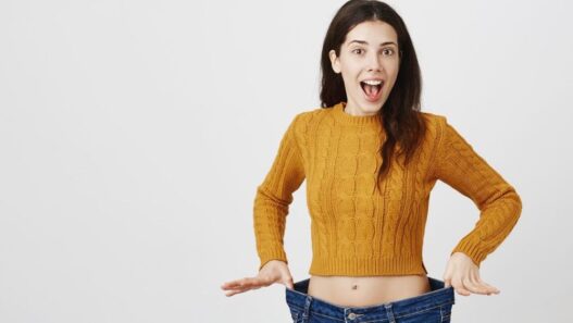 Woman showing loose jeans and weight loss