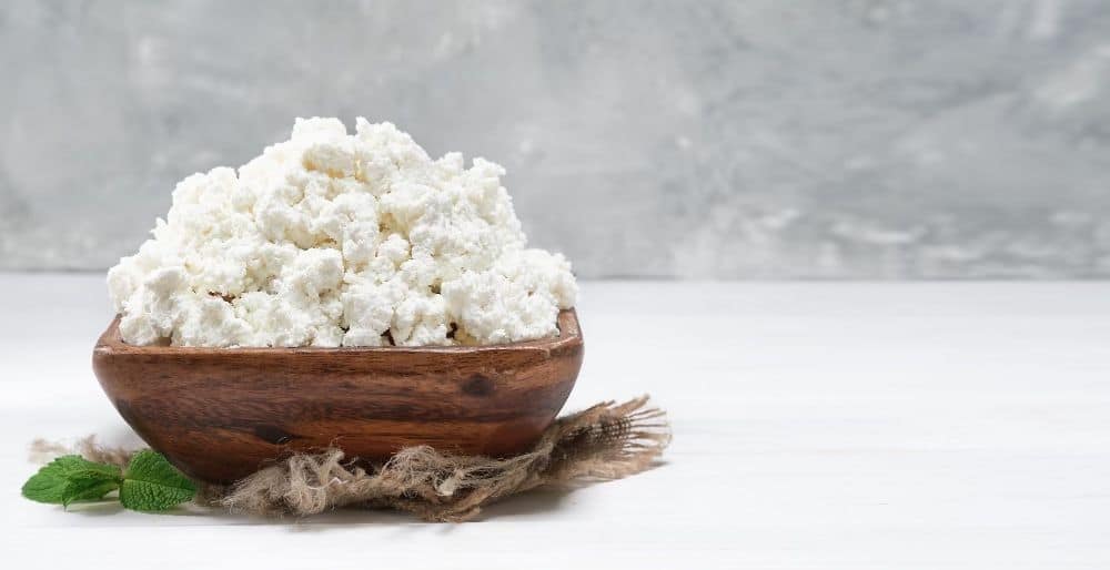 Cottage cheese in wooden bowl, eggs and cottage cheese for weight loss