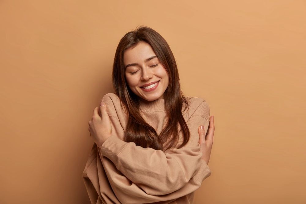 Woman happy arms around herself for self care in mental health toolbox
