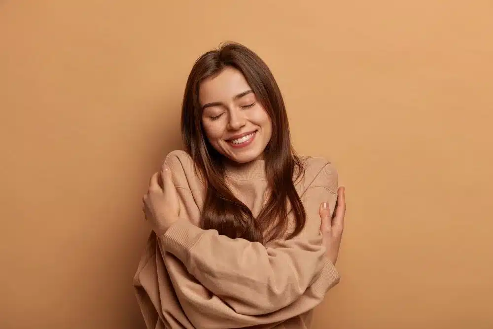 Woman happy arms around herself for self care in mental health toolbox