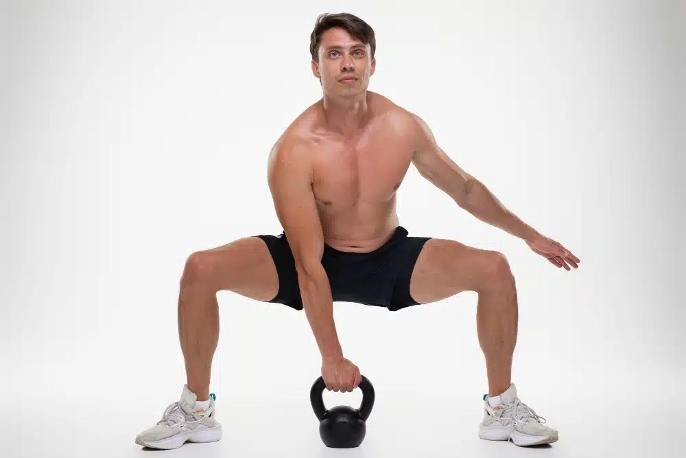 Man with kettlebell doing squats for peak performance training