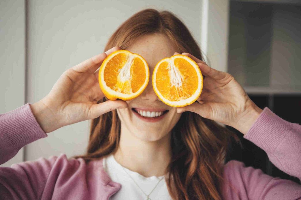 woman showing nutrition two oranges close to her eyes for nutrition and eye health