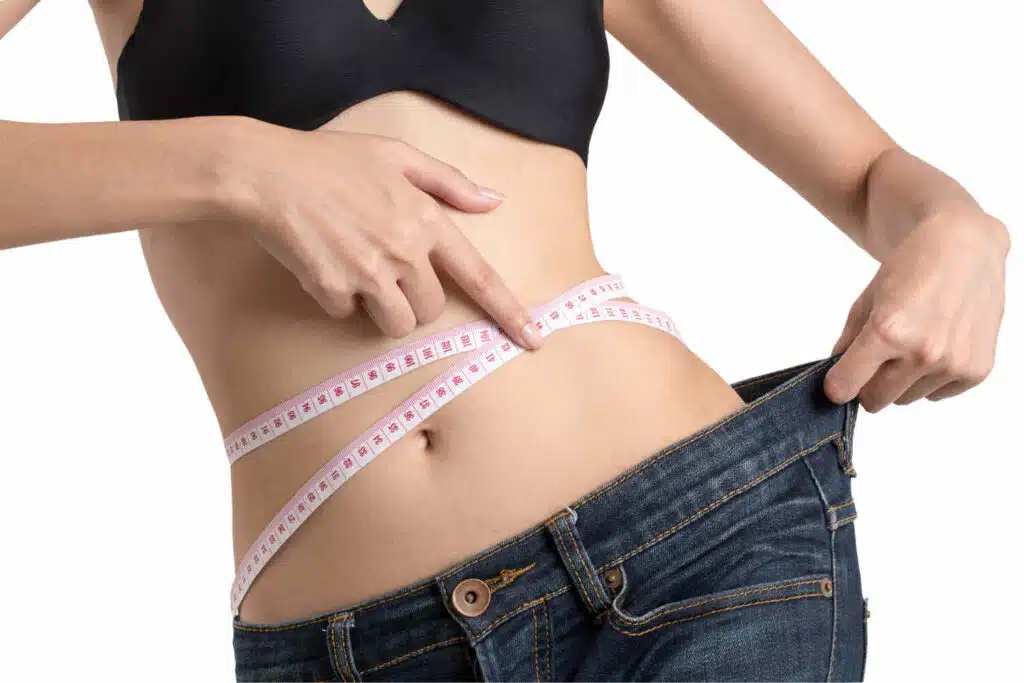 Vshred reviews, Woman showing loose jeans and measuring with inchtape