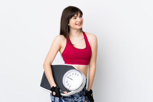woman holding weighing machine in phenq reviews blog