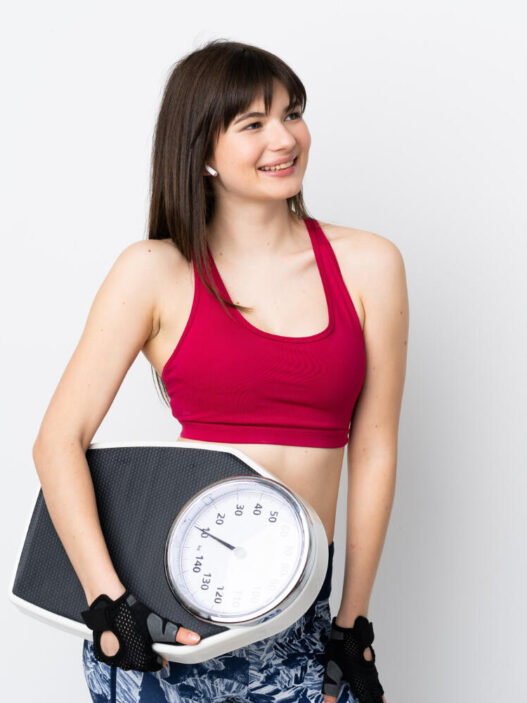 woman holding weighing machine in phenq reviews blog