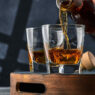 bottle pouring whiskey in two glasses