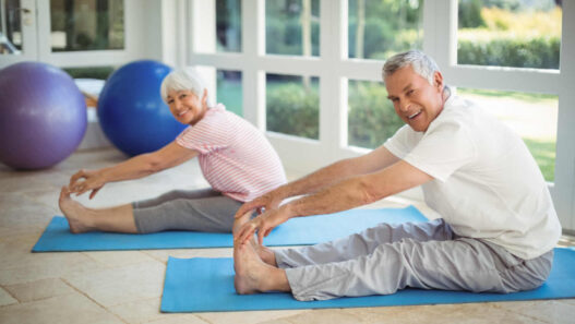 two senior man and woman doing gentle yoga