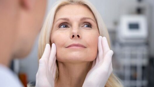 Doctor examining woman for facelift surgery or rhytidectomy