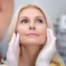 Doctor examining woman for facelift surgery or rhytidectomy