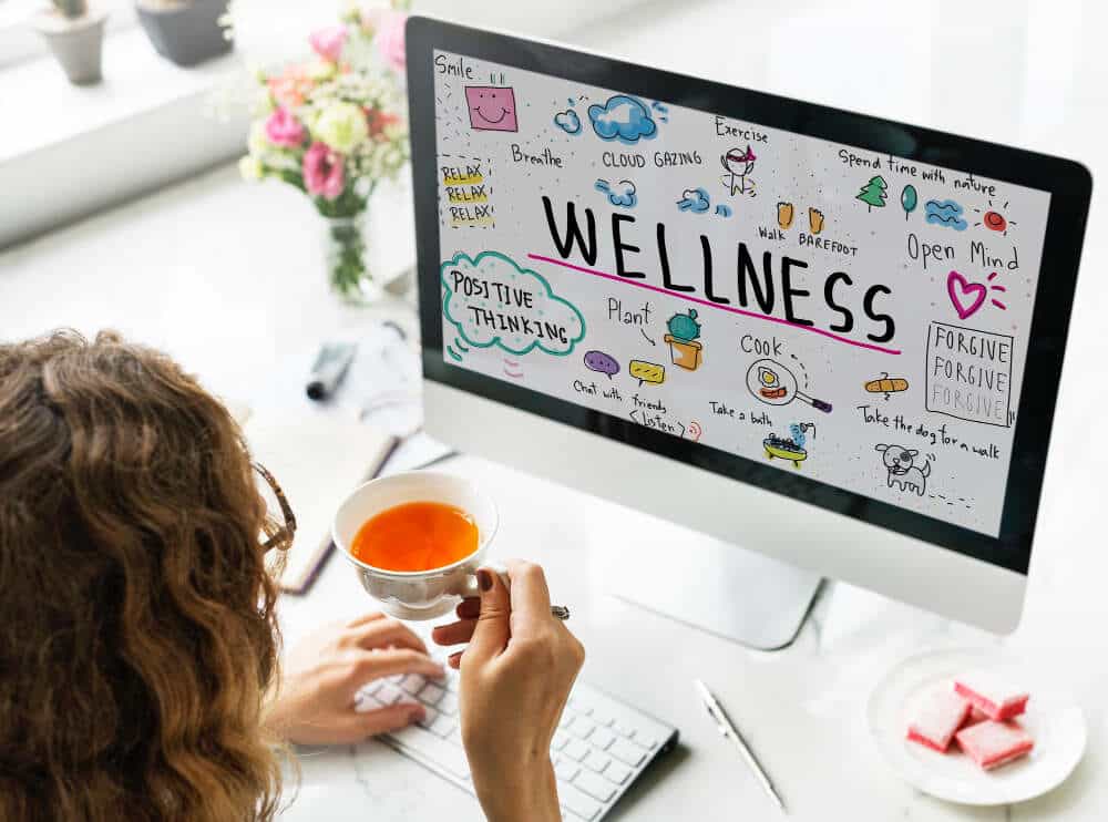 Woman reading wellness on laptop, Self-care, Self-exhaustion, Wellness Fatigue