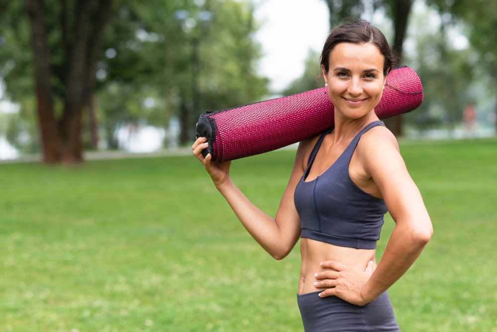 Woman with fitness mat, back to the grind