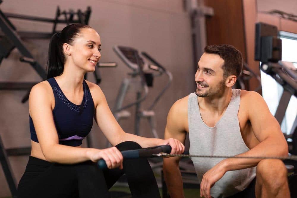 Coach with woman cycling at gym, Back to the grind