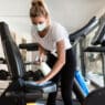 Woman cleaning the cycle in gym